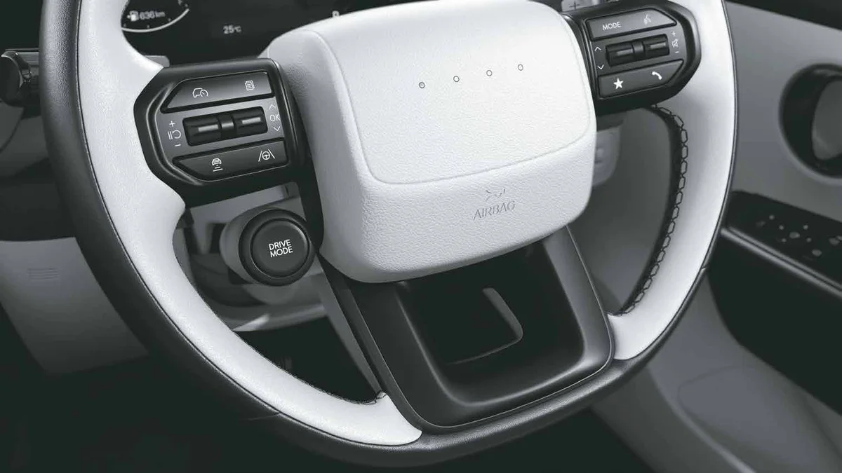The Hyundai Bayon's two-spoke steering wheel with a Drive Mode button below the right spoke